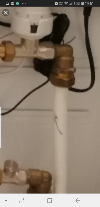 Närbild på ett rör med en pil, indikerande flödesriktning, som kanske är felkopplat till en fördelare.