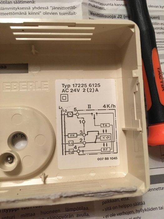Bild på ett öppnat rumstermostatfodral med synligt kopplingsschema och tekniska beteckningar.