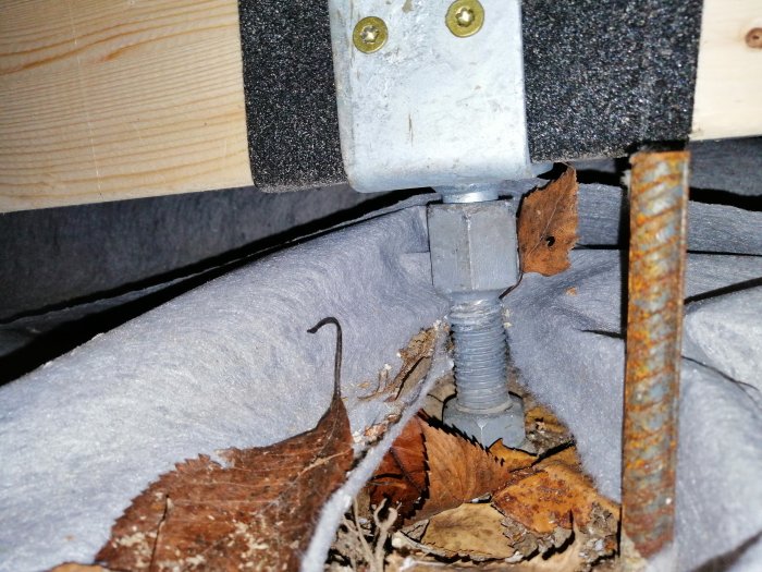 Justerbar stolpsko ingjuten i betong med limträbalk och armeringsjärn.