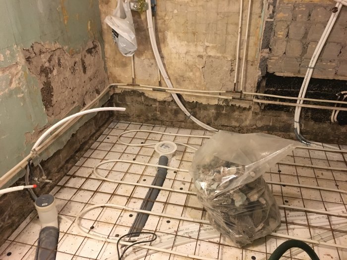 Renoveringsarbete i badrum med borttagen träullit, primer applicerad och förberedelse för gjutning.