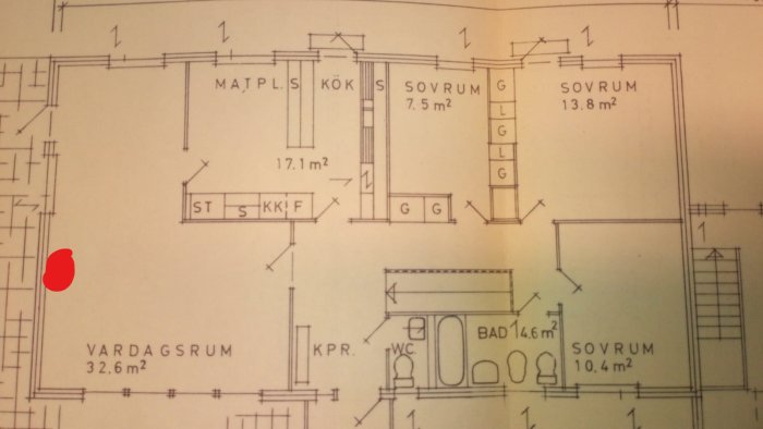 Planritning av ett hus med markerat område för kamininstallation i vardagsrummet nära sovrum.