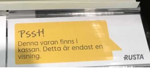 Informationsskylt som informerar att produkten enbart finns vid kassan och inte på plats.