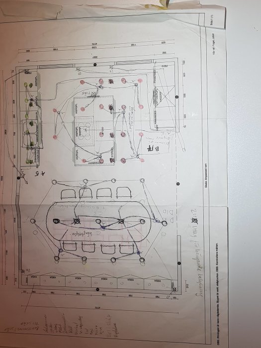 Handritad skiss över kökslayout med markerade platser för spotlights och strömbrytare noterade med färg.