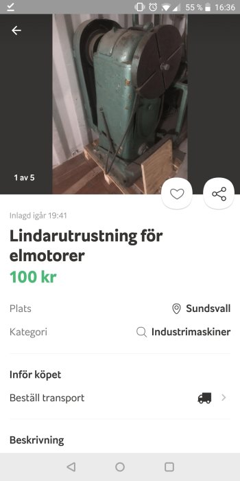 Gammal industriell elektrisk motor monterad på en träpall, med grön färg och flagnad färg.