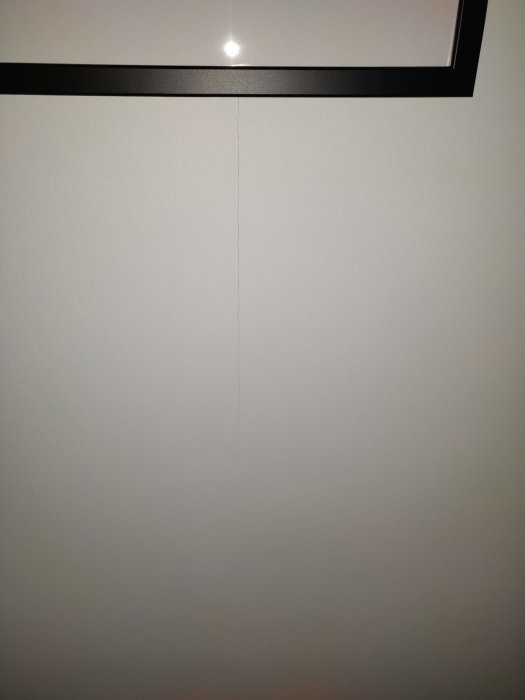Vertikal spricka på en vägg i ett rum där det tidigare funnits ett fönster.