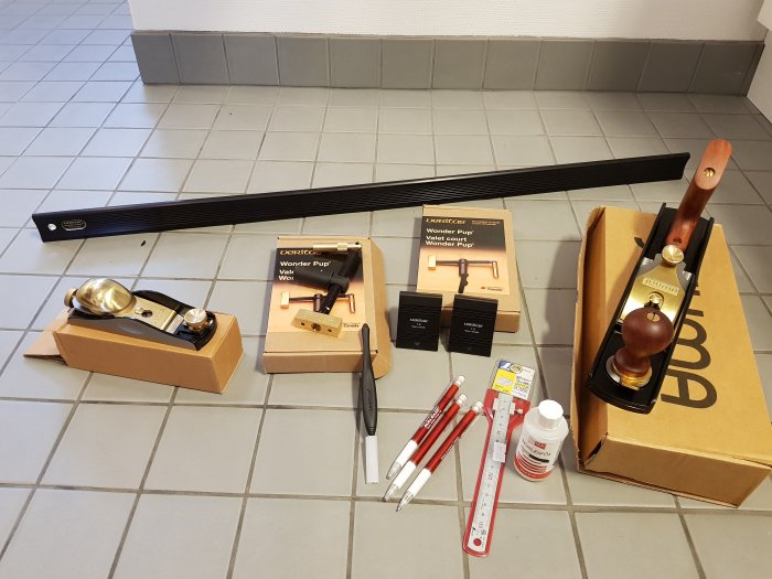 Verktyg för snickeri och finjustering, inklusive handhyvel, markeringstuschar och förpackningar.