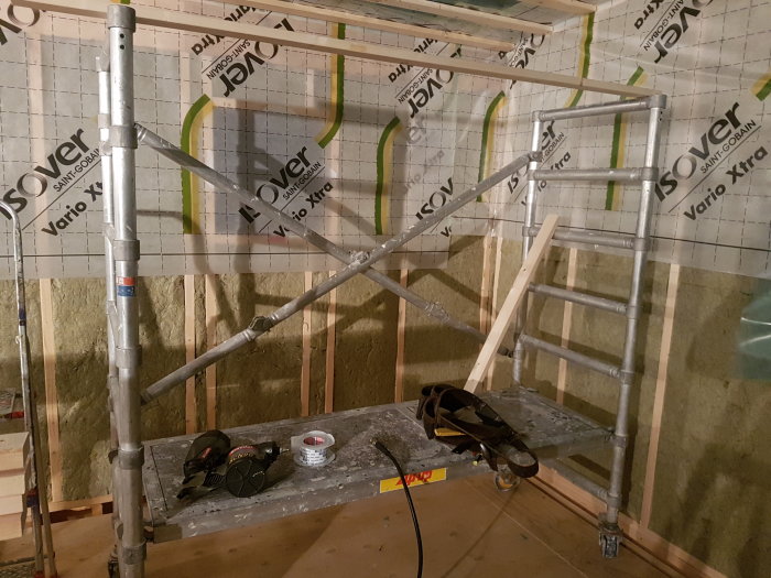 Begagnad rullställning i ett rum med spikad glespanel och isolering på väggarna.