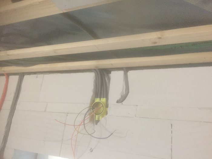 Elledningar installerade genom väggen och taket i ett garage under renovering.