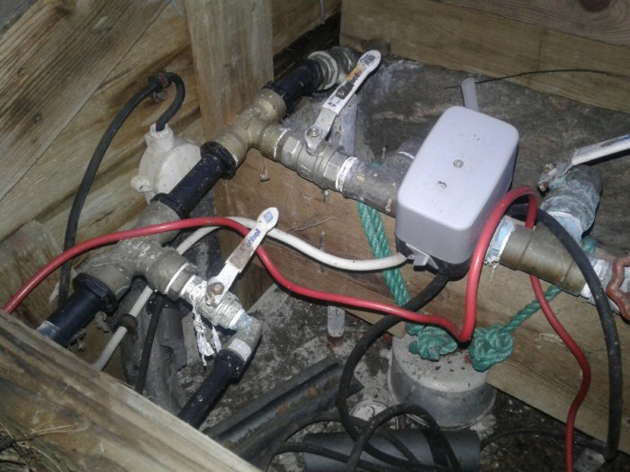 Vattenpumpsystem med rörkopplingar, en trolig tryckvakt och kablar, undrar om brist på tryckkärl.