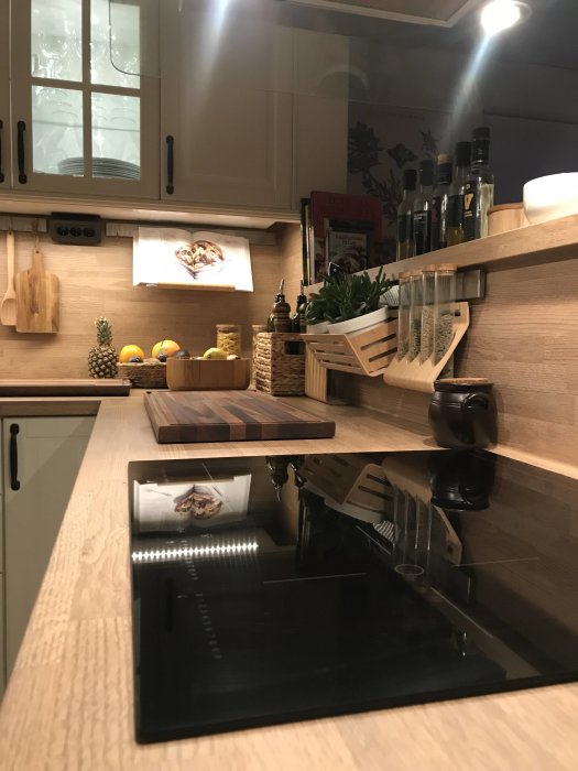 Nyrenoverat kök med träskåp och -bänkskivor, inbyggda spotlights, köksredskap och en öppen kokbok.