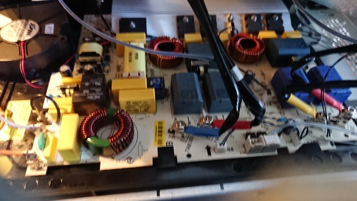 Inre komponenter och kretskort i en Electrolux spishäll från 2010, utan synliga brännskador.