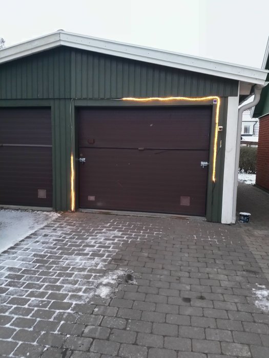 Ljusslinga delvis upplyst längs kanten av ett garagetak, resten av slingan släckt.