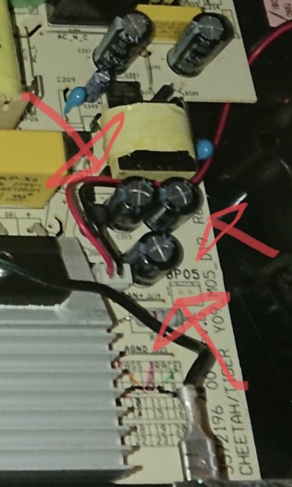 Elektroniskt kretskort med kondensatorer och anteckningar markerade med rött.
