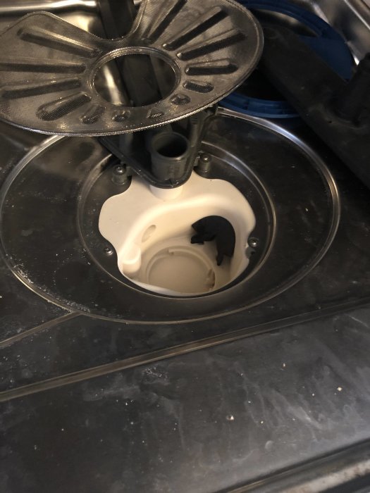 Interiör av en diskmaskin med öppet filterområde och synliga rester som kan orsaka problem.