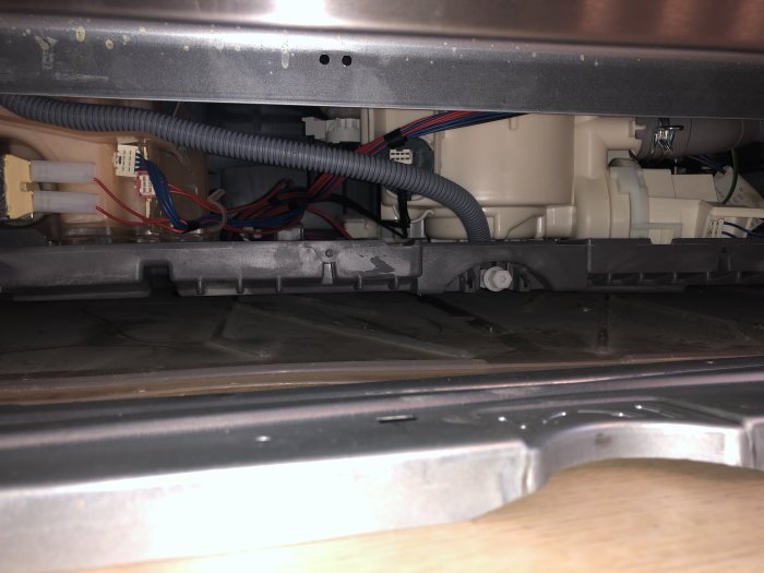 Vy under diskmaskin som visar ledningar och komponenter, med felkod relaterad problematik.