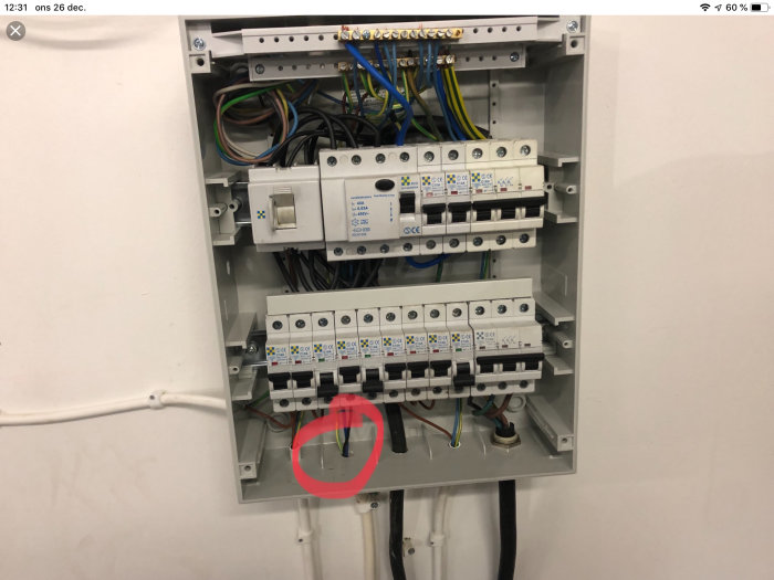 Elcentral med öppet kabelskydd och kablar markerade med röd cirkel.
