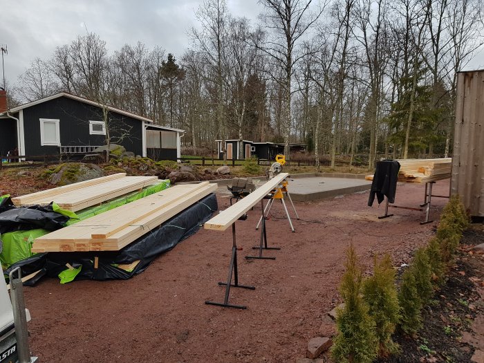 Material och verktyg förberedda för byggandet av en garagestomme med plats för solpaneler.