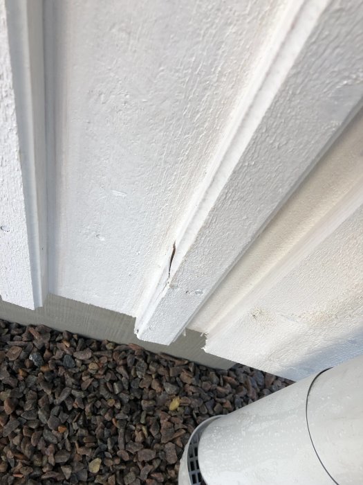 Nahaufnahme von Mängeln im Außenverkleidung eines neu gebauten Hauses, mit Fokus auf einer sichtbaren Rissbildung.