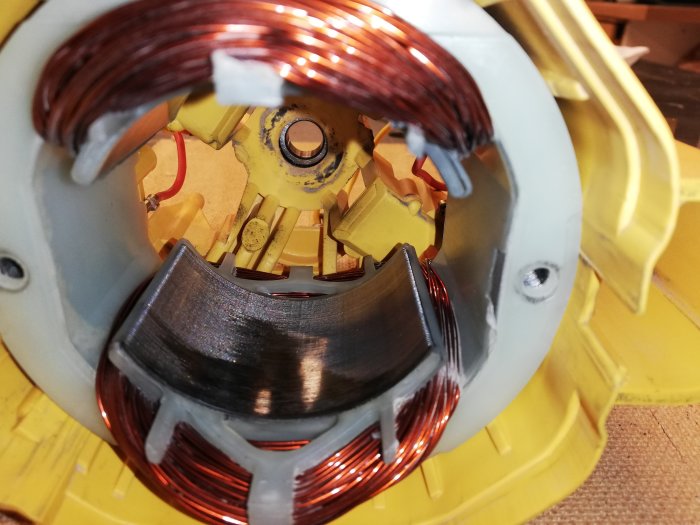 Närbild av elektrisk motor med synlig stator och rotor, tecken på skrapmärken där rotorn troligen har tagit i statorn.