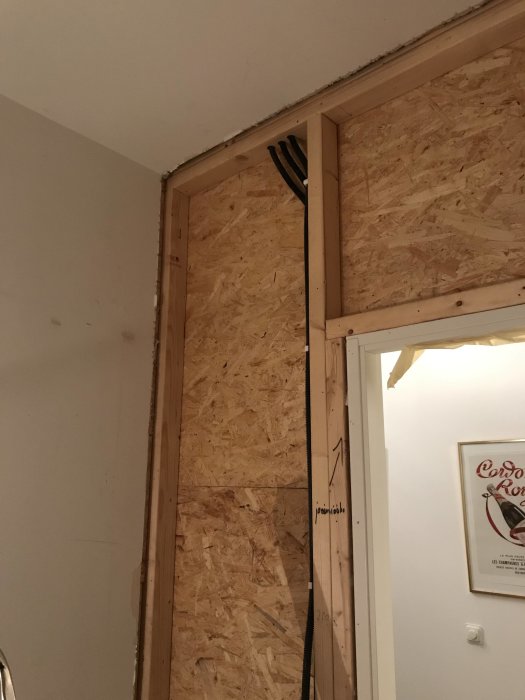 Rivningsarbete i rum med träreglar och OSB-skivor exponerade där en vägg tagits bort.