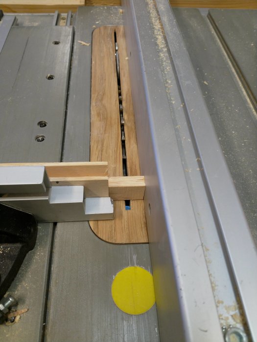 Träbit som bearbetas på bordsåg i verkstad, för att skapa tappar till skåpfronter.