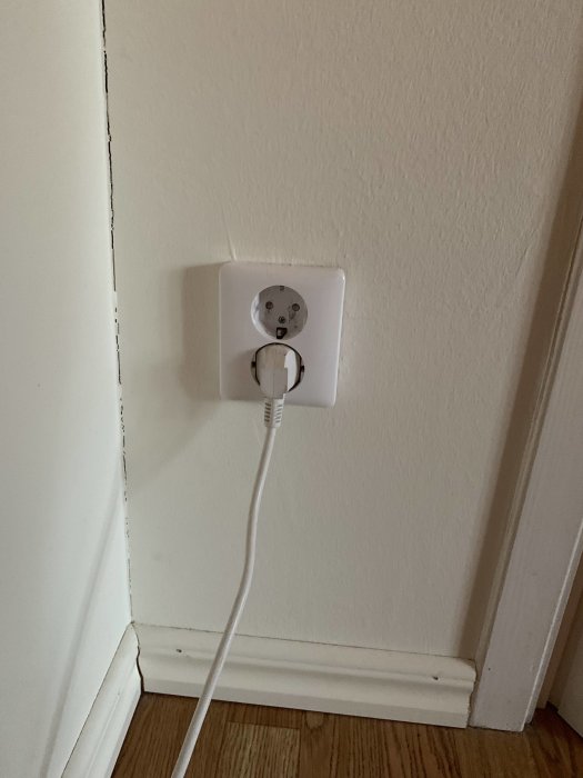 Eluttag vid dörrkarm med ansluten vit kabel, stängd inga uttag på motsatt sida.