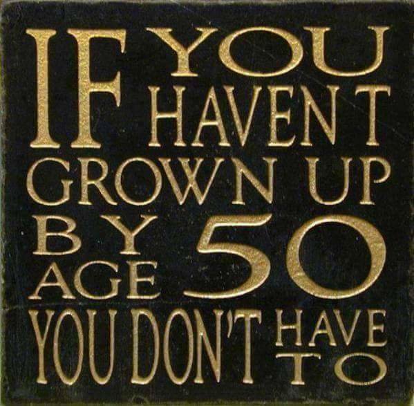 Träskylt med texten "If you haven't grown up by age 50 you don't have to" i guld mot en svart bakgrund.
