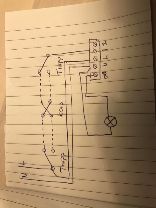 Handritad skiss av en elektrisk kopplingsschema på linjerat papper.