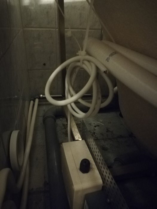 Under en jacuzzi visar rör och avklippt elkabel, indikerar ouppkopplade installationer och möjlig vattenskada.