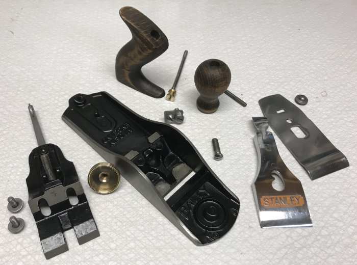 Polerade och målade delar till en hyvel inklusive svartmålad kropp, stålkniv och trähandtag.