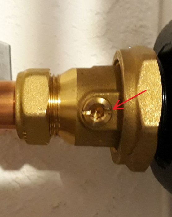 Messingventil med röd pil som pekar på en liten läcka.
