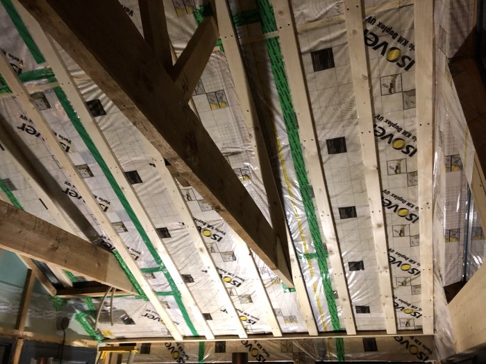 Tak under konstruktion med isolering och träreglar synliga, redo för slips och elinstallationer.