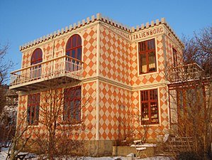 Restaurerad eternitfasad på en kulturskyddad villa i mönstrad design med balkong och vinterträdgård.