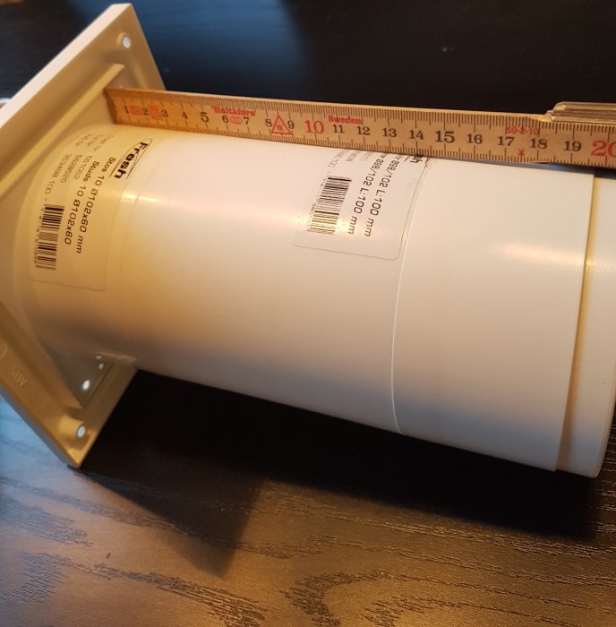 Ett vitt modulrör mätt med en tumstock, visar längd ca 19,7 cm på en mörk yta.