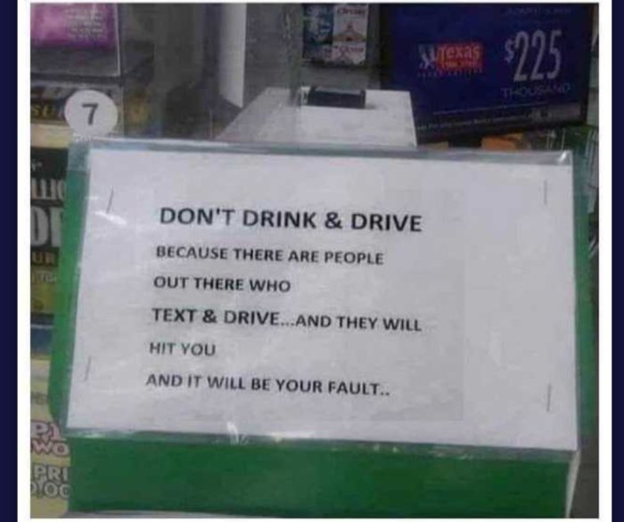 Skylt med texten "Don't drink & drive because people who text & drive will hit you and it will be your fault" i ett fönster.