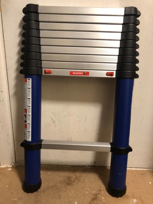 Sammanfälld Telesteps Blue Line stege på 3 meter står mot en vägg i bra skick.
