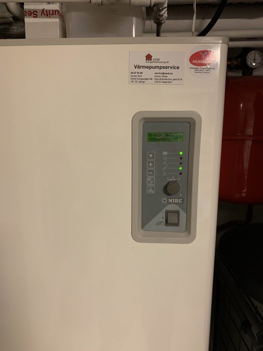 Nibe Fighter 1215 värmepump med kontrollpanel och inställningar i ett pannrum.