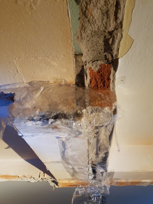 Delvis rivet ventilationssystem med synligt rörmaterial, omgivet av plast, efter väggrivning.