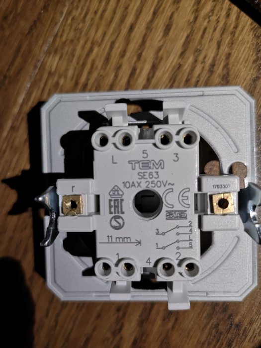 Öppen strömbrytare som visar svarta och turkosa kablar anslutna, märkt för elinstallation.