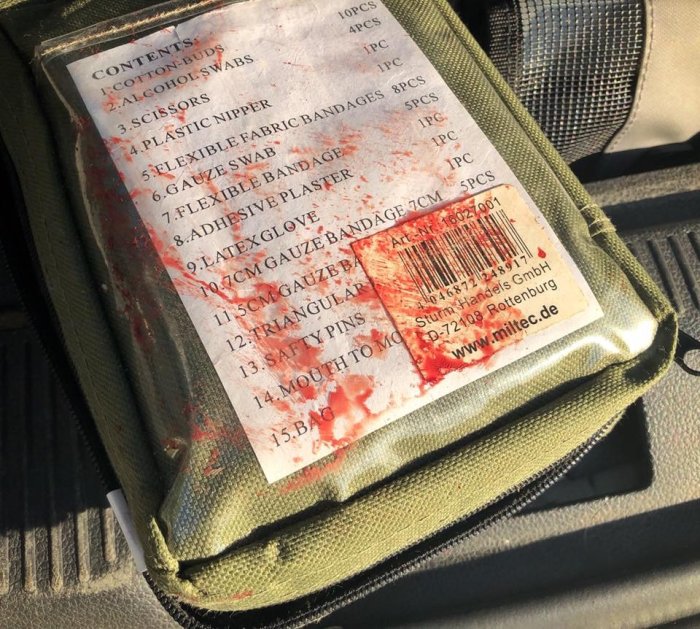 Förstahjälpenväska täckt med blod efter användning vid en trafikolycka.