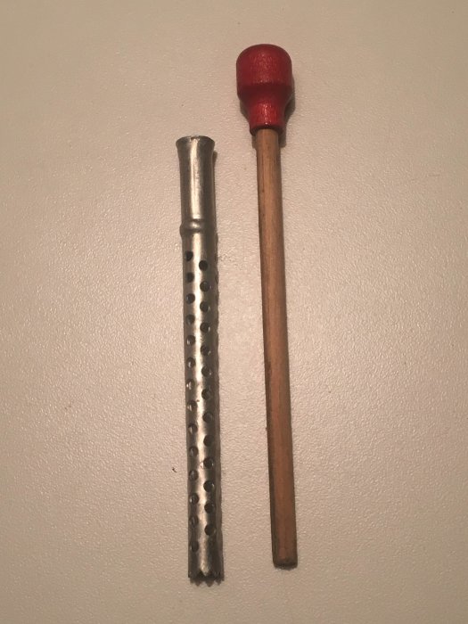 Okänd köksredskap med taggig aluminiumdel och trähandtag, eventuellt för kryddning.