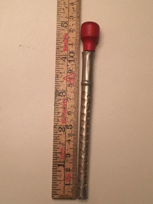 Okänd köksredskap i aluminium med taggig ände bredvid en tumstock som visar längden 12,5 cm.