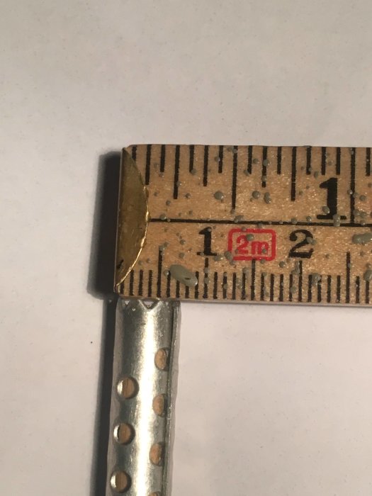 Koniskt metallrör med taggig ände bredvid linjal som visar 7 mm bredd.