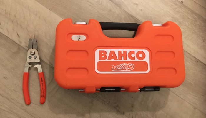 Bahco S330 hylsnyckelsats i orange förvaringslåda och en ställbar låsringstång med röda handtag på en trägolv.