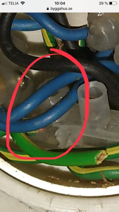 Elkablar och en märkt skadad kabel i en elkopplingsdosa.