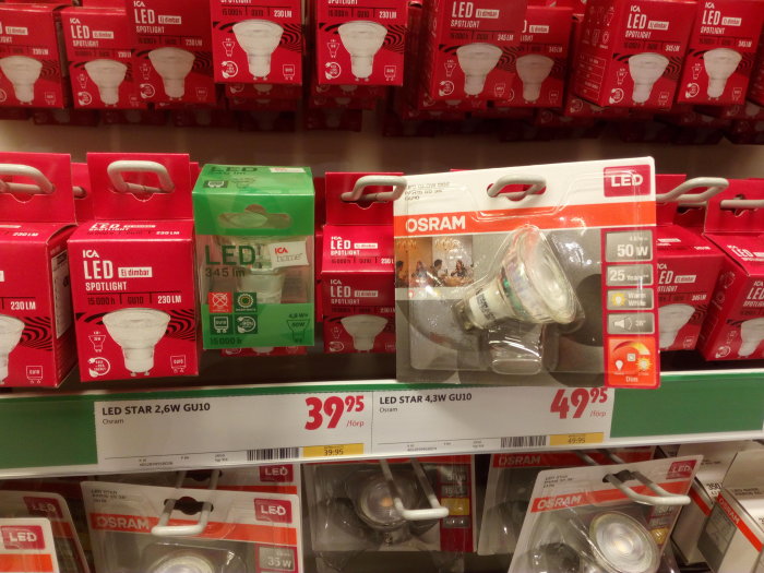 LED-spotlights i förpackning på butikshylla, inklusive dimbara och färgtemperaturjusterbara versioner.