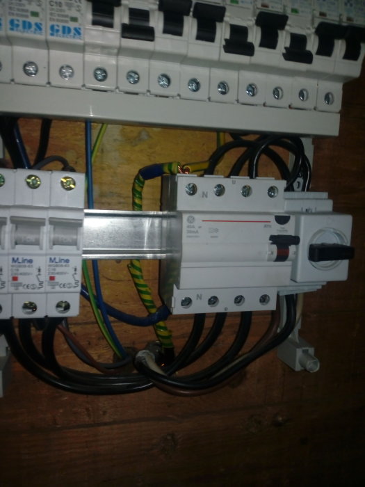 Elcentral med säkringar och en jordfelsbrytare, inkopplade kablar och en osäker TN-C systemkonfiguration.