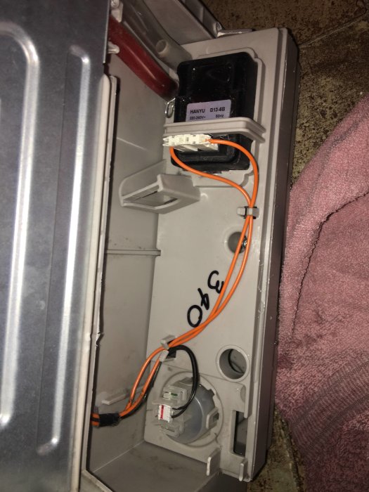 Öppen tvättmaskin visar pump och elektriska komponenter för felsökning av tömningsproblem.