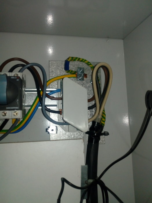 Elektrisk installation med skalade kablar och anslutningsdosor i elskåp.