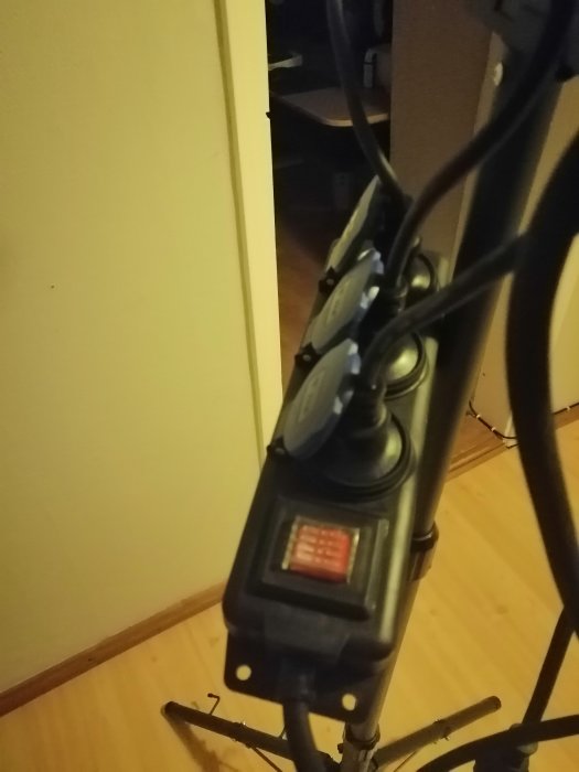 Grenuttag med brytare och flera inkopplade kablar monterat längs en stolpe.